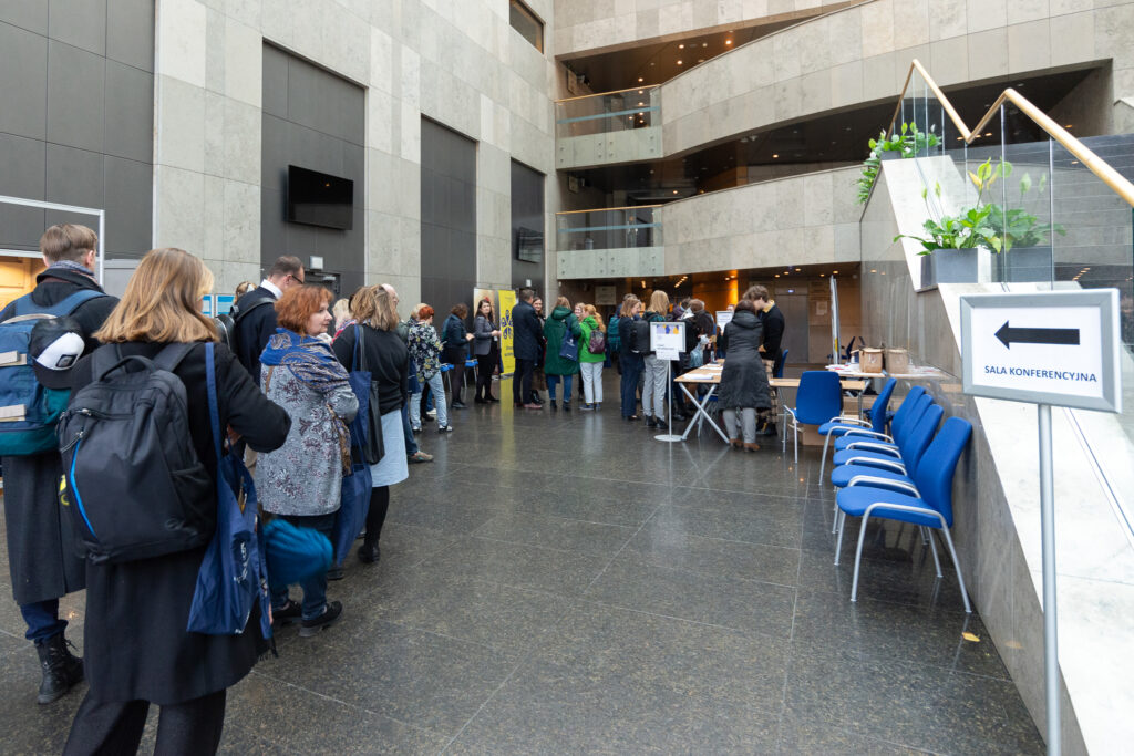 Uczestnicy konferencji oczekują na odbiór pakietów konferencyjnych