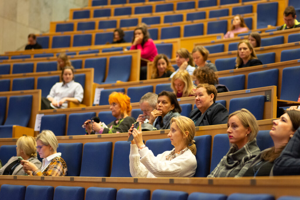 Amfiteatralna sala konferencyjna z wypełniona ludźmi