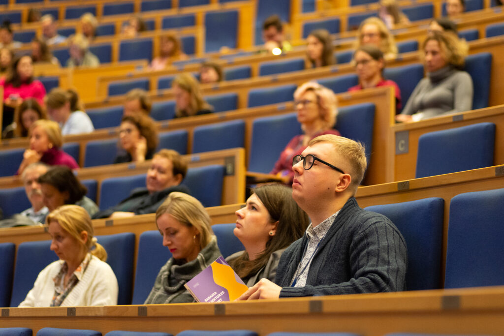 Amfiteatralna sala konferencyjna z wypełniona ludźmi