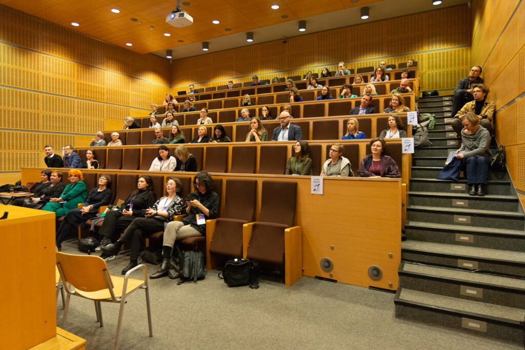 Amfiteatralna sala konferencyjna z wypełniona ludźmi